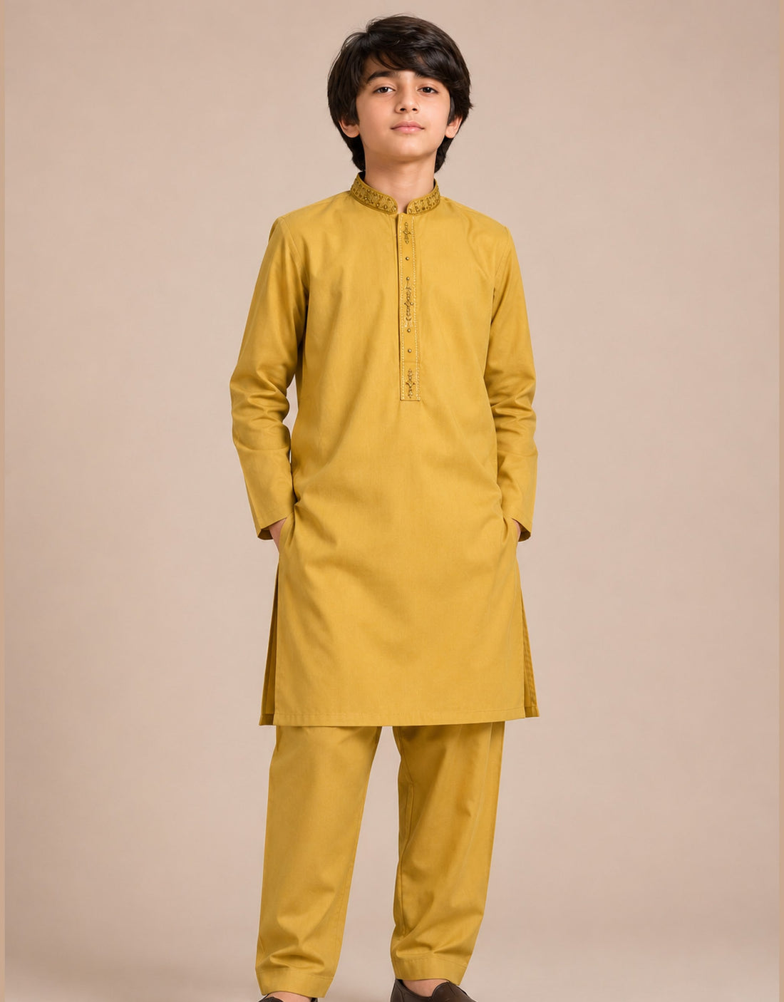 Boy wearing a mustard yellow embroidered cotton lawn chambray kurta shalwar by Harisan Wear
