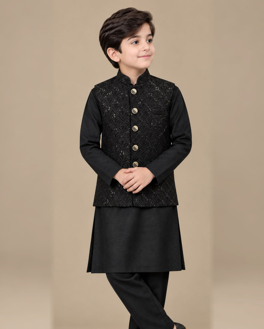Boy wearing a black embroidered waistcoat suit with kurta shalwar by Harisan Wear